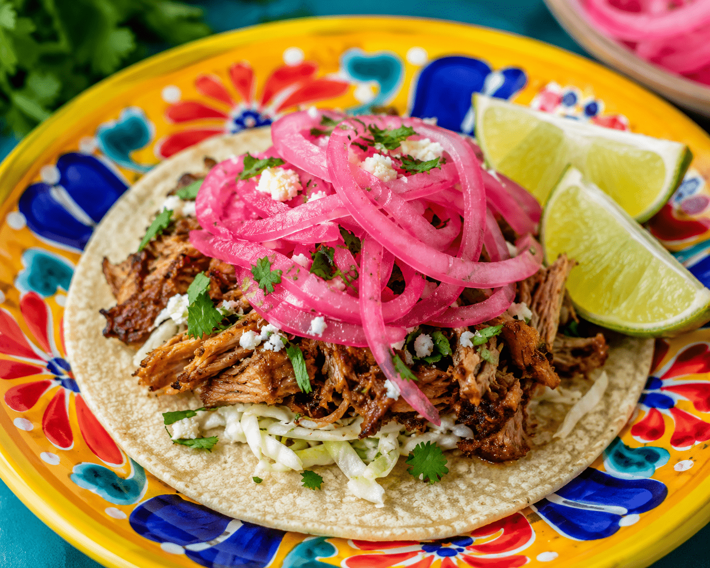 Pickled Red Onions on a taco with lime wedges.